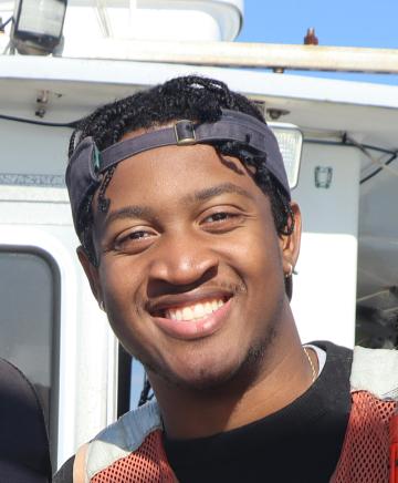 A young man on a boat smiling